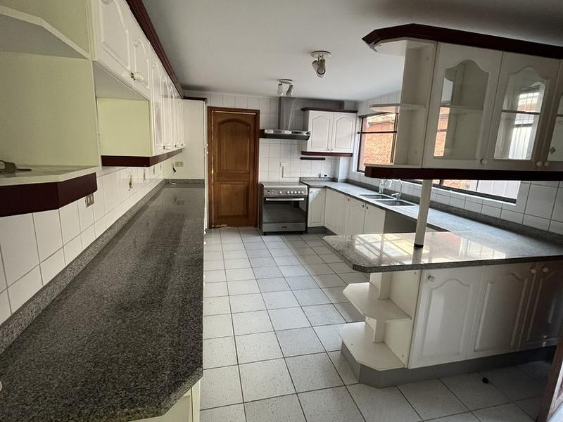 Cocina antes de remodelar, con muebles blancos y cubiertas de granito